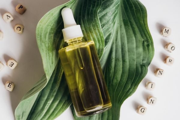 Hemp seed oil dropper bottle on a leaf