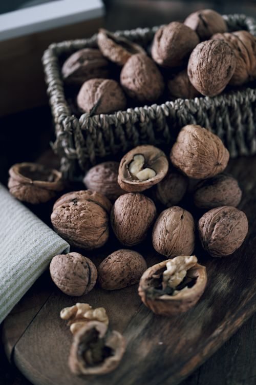 Basket of walnuts on a wooden board