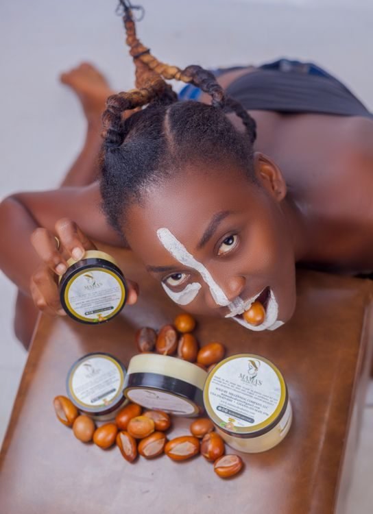 Woman biting a shea nut